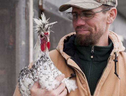 Our farmer Matthew holds a Spitzhauben breed of chicken, photo taken and published by The Province.